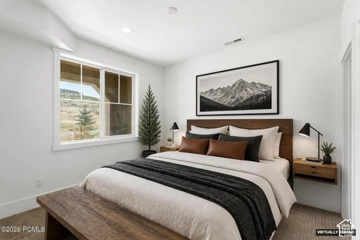Recessed lighting, wood-finish flooring, white walls, large window with muntins, and a wood headboard