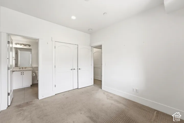 Recessed lighting, arched panel closet doors, and carpeted flooring