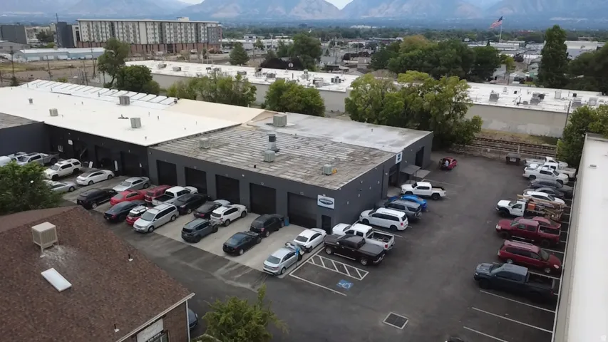 Commercial building with multiple bay doors, large paved parking area, and a flat roof