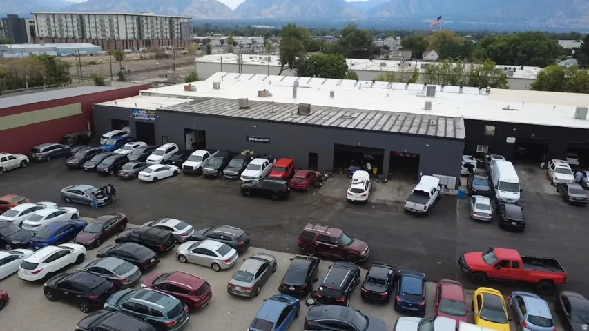 Commercial building with multiple service bays, asphalt parking lot, and flat roof