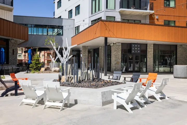 Outdoor patio with a central fire pit feature, surrounded by Adirondack-style seating