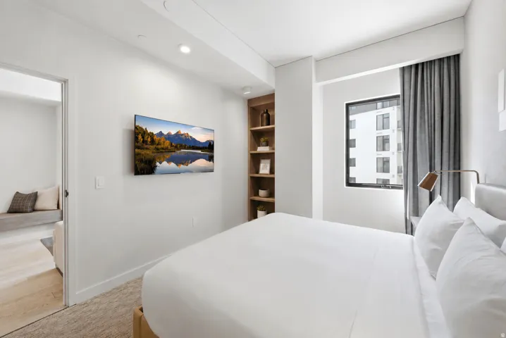 Built-in shelving, recessed lighting, and a wall-mounted television enhance this space
