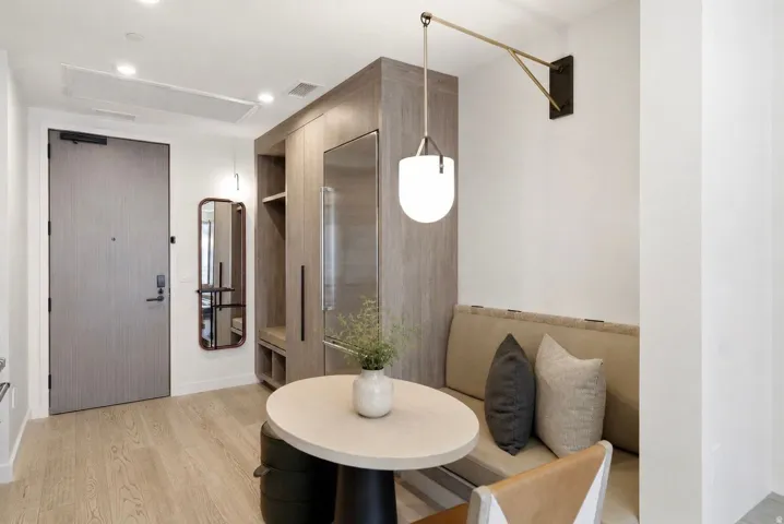 Entryway with wood-finish flooring, built-in storage cabinetry, integrated refrigerator, and a built-in banquette
