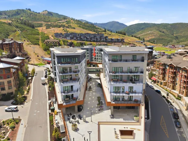 Modern multi-story buildings with expansive balconies and mountain scenery