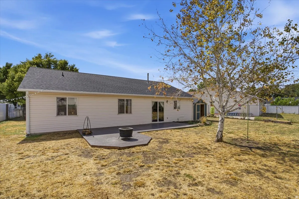 Rear exterior with horizontal siding, dark shingle roof, and a sliding glass door