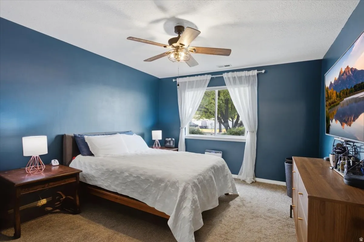 Room featuring a window, ceiling fan, and carpeted flooring