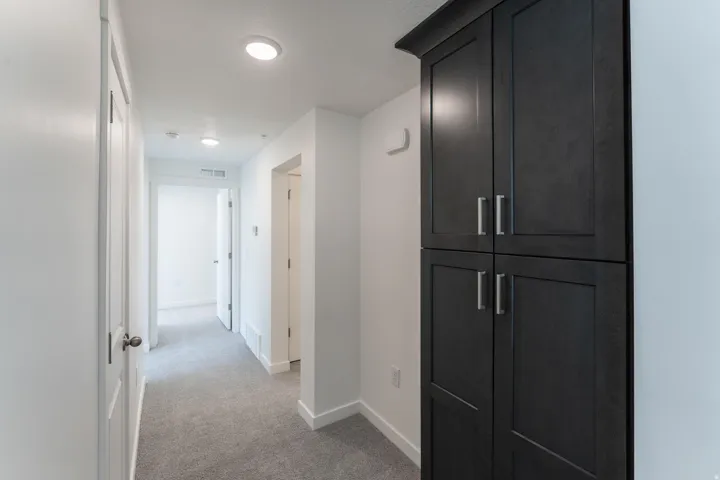 Hallway featuring gray carpet flooring and recessed lighting
