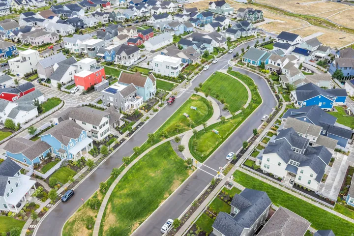 Aerial view of a well-planned residential community featuring tree-lined streets, manicured green spaces, and curved cul-de-sacs