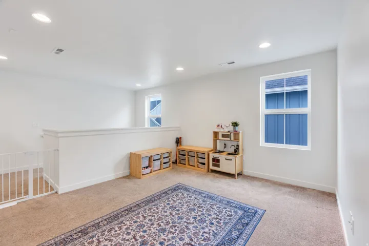 Carpeted room featuring white walls, recessed lighting, and multiple windows with white frames