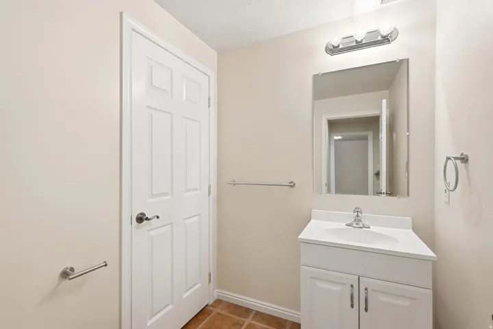 White vanity with chrome hardware, an integrated sink, and a chrome faucet