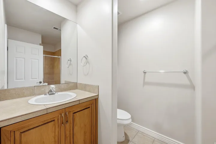 Vanity with a built-in sink and wood-finish cabinetry, set against a full-width mirror