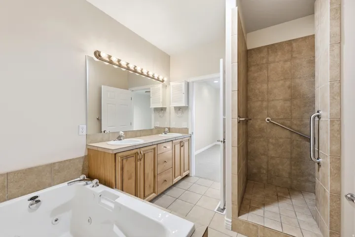 Dual vanity with integrated sinks, full-width mirror, and overhead strip lighting