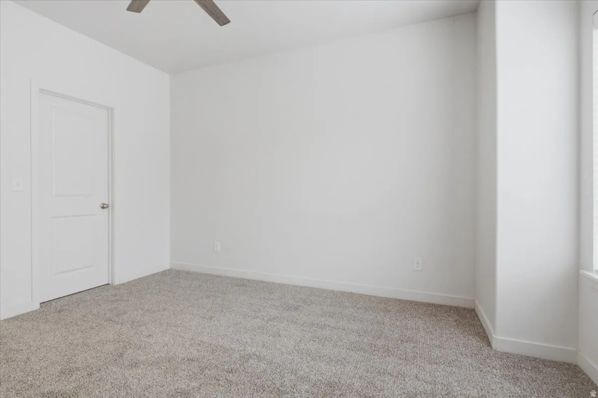 Light gray carpeting, white walls, and a two-panel interior door with a brushed nickel knob