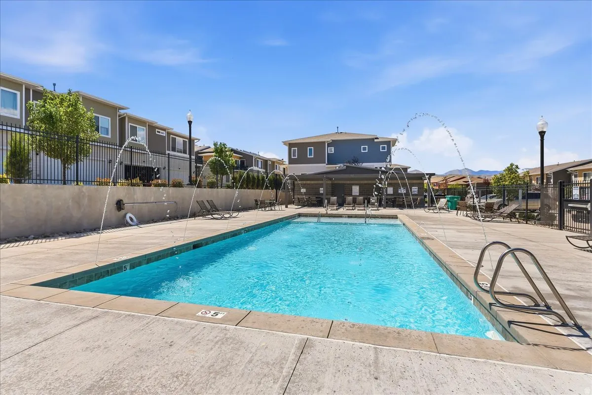 Outdoor swimming pool with integrated water features and a surrounding concrete deck