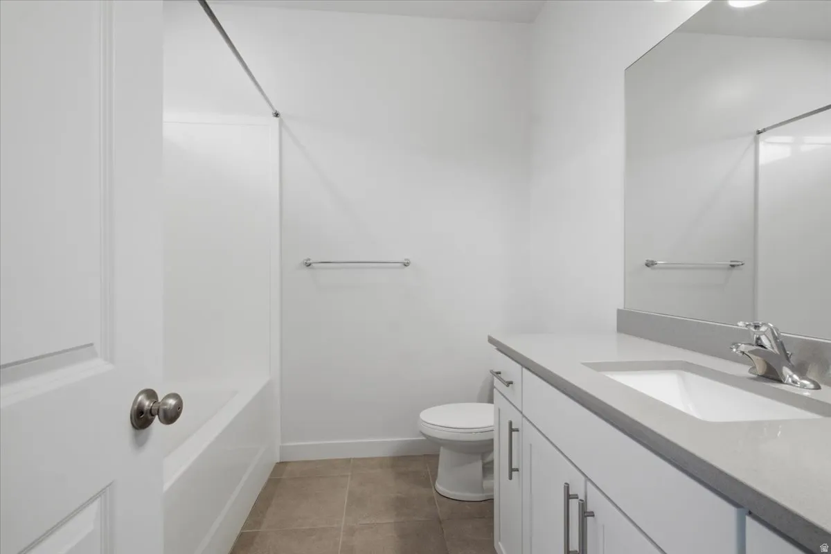 White vanity with rectangular undermount sink, light gray countertop, and chrome faucet