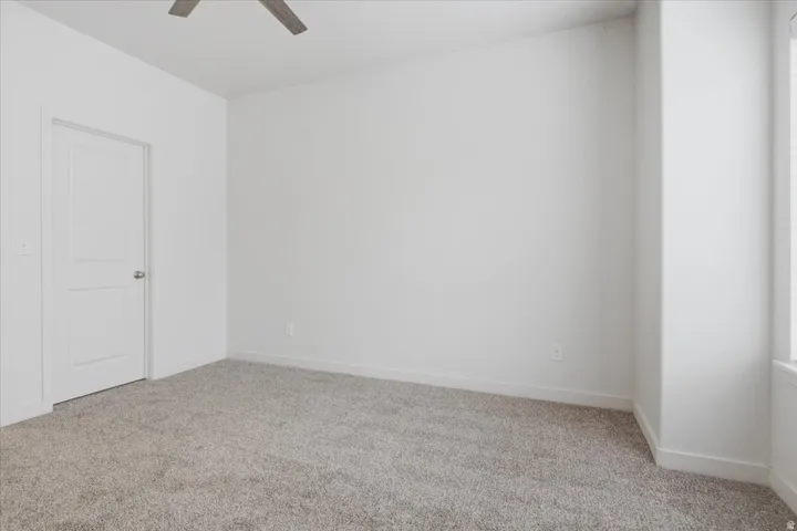 Light gray carpeting, white walls, and a two-panel interior door with a brushed nickel knob