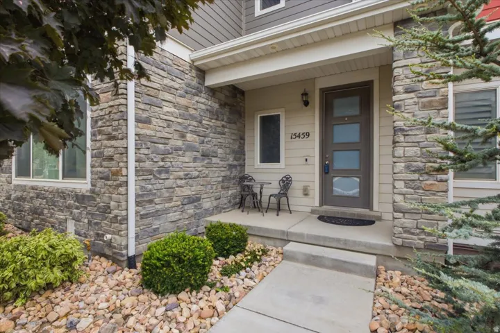 Stone veneer facade with siding accents, covered entry, and concrete walkway