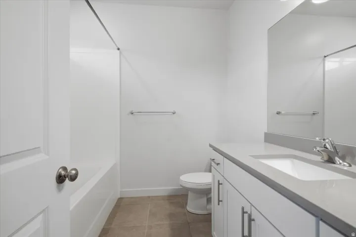White vanity with rectangular undermount sink, light gray countertop, and chrome faucet
