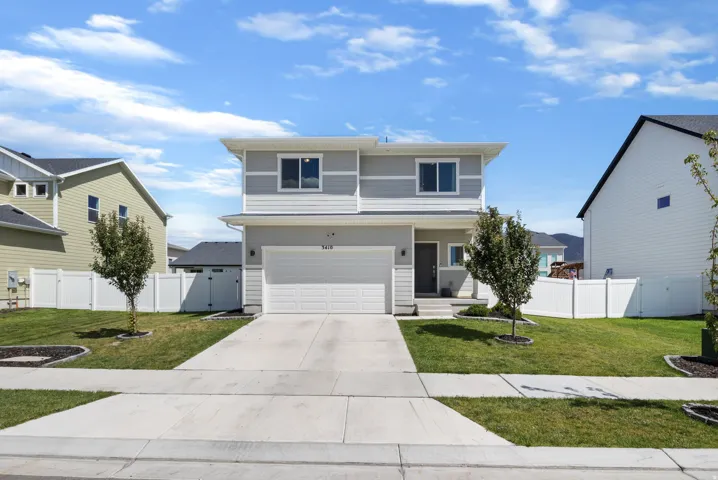 Two-story residence featuring light gray siding, white trim, and a two-car garage