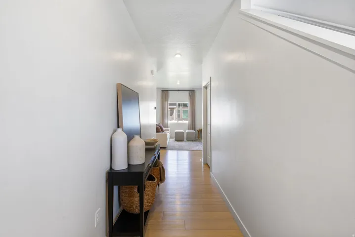 Hallway with light wood-finish flooring and white walls