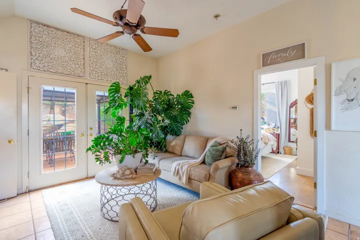 Vaulted ceiling with ceiling fan, tile flooring, and French doors leading to an outdoor area