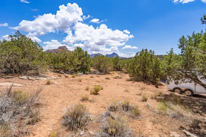 Arid landscape featuring native vegetation, rock outcroppings, and distant mountain ranges