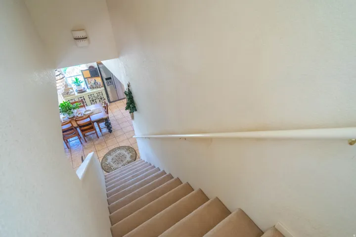 Carpeted staircase with a wall-mounted handrail