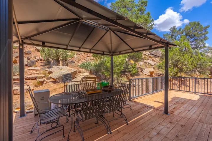 Expansive outdoor deck with wood-finish flooring, metal railing, and a permanent covered pergola