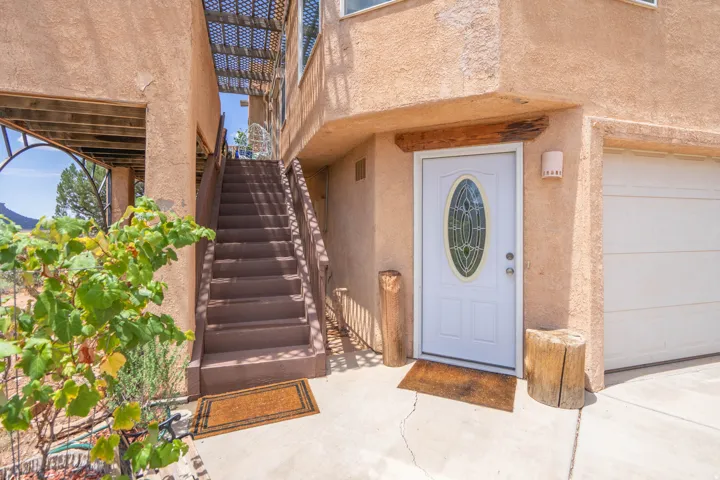 Stucco exterior with a covered entry, a white front door featuring an oval leaded glass insert, and an attached garage with a panel door