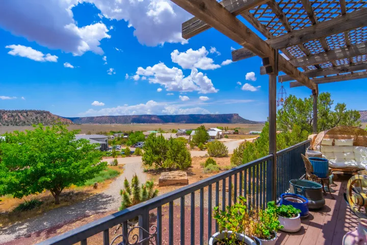Expansive outdoor deck with a wooden pergola, black metal railing, and a durable wood-finish deck surface