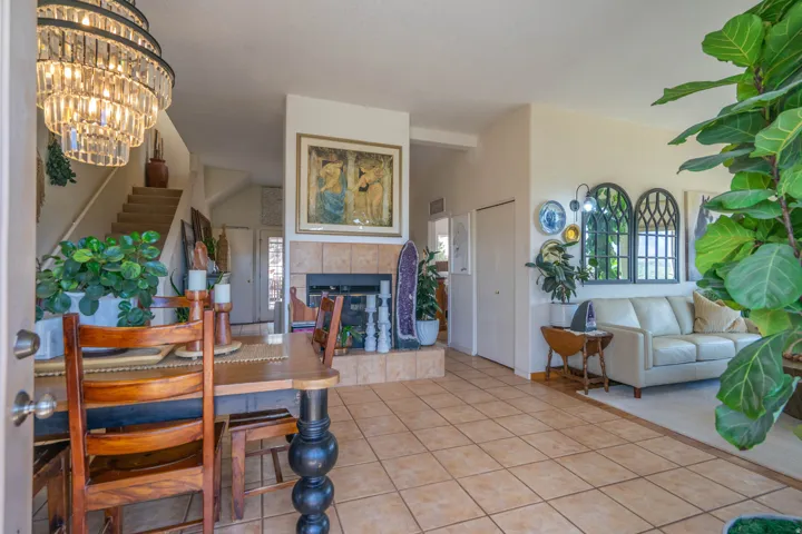 Tile flooring, a built-in fireplace with a tile surround, a crystal chandelier, and a carpeted staircase