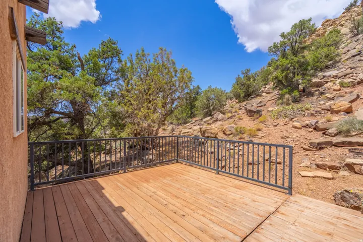 Expansive wood-finish deck with metal railings and a textured stucco exterior