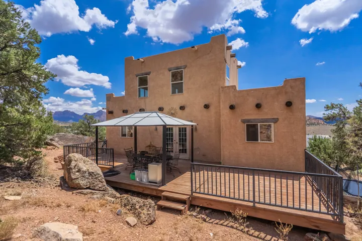 Southwestern-style exterior with a wood-finish deck and black metal railings