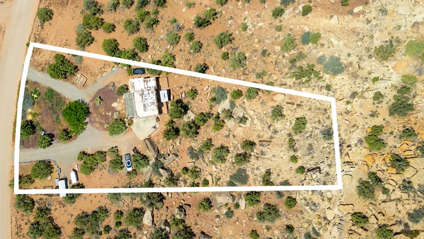 Expansive parcel featuring a main residence, detached structure, and gravel driveway