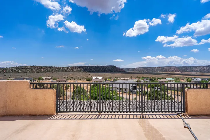 Expansive outdoor terrace with a stucco parapet wall and metal railing