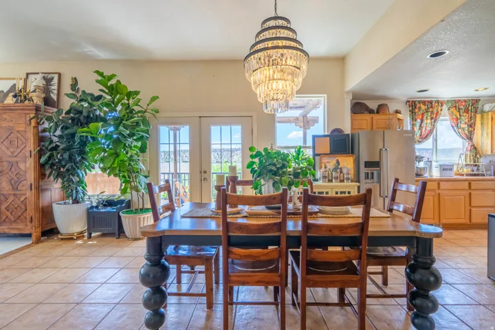 Ceramic tile flooring, a tiered chandelier, and double French doors with transom windows