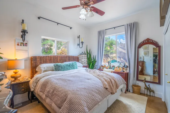 Recessed window with exterior scenery, overhead ceiling fan with lighting, and sconce lighting fixtures