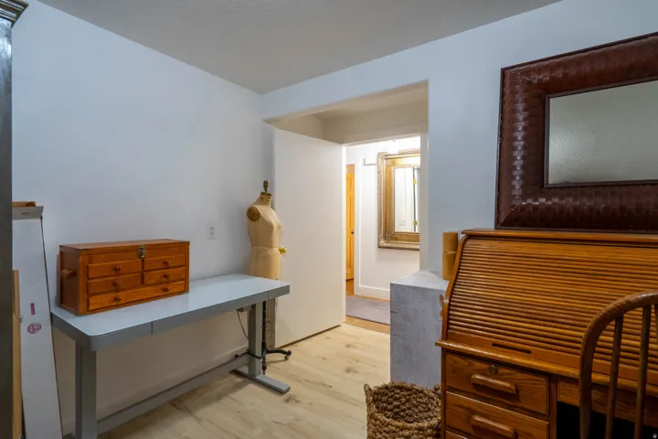 Wood-finish flooring with white walls and a bright doorway