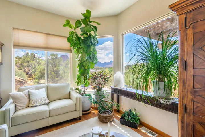 Expansive windows with mountain scenery, rich wood-finish flooring, and natural light