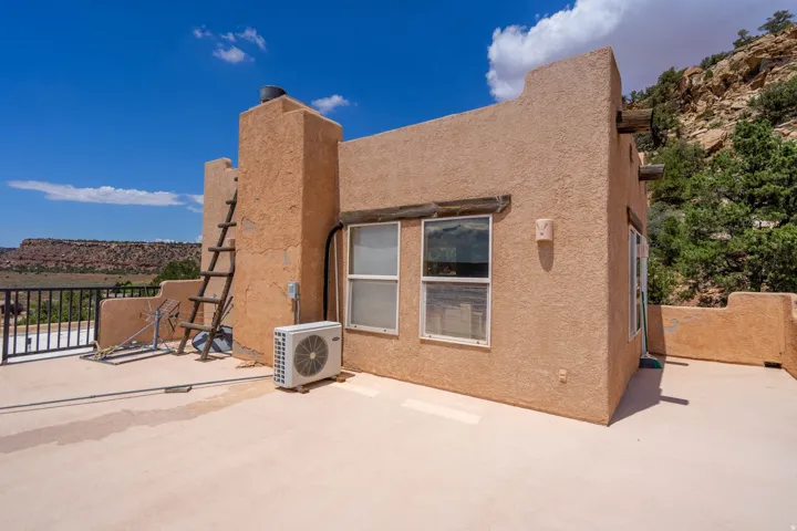 Terrace featuring a flat roof, stucco exterior, and black metal railing