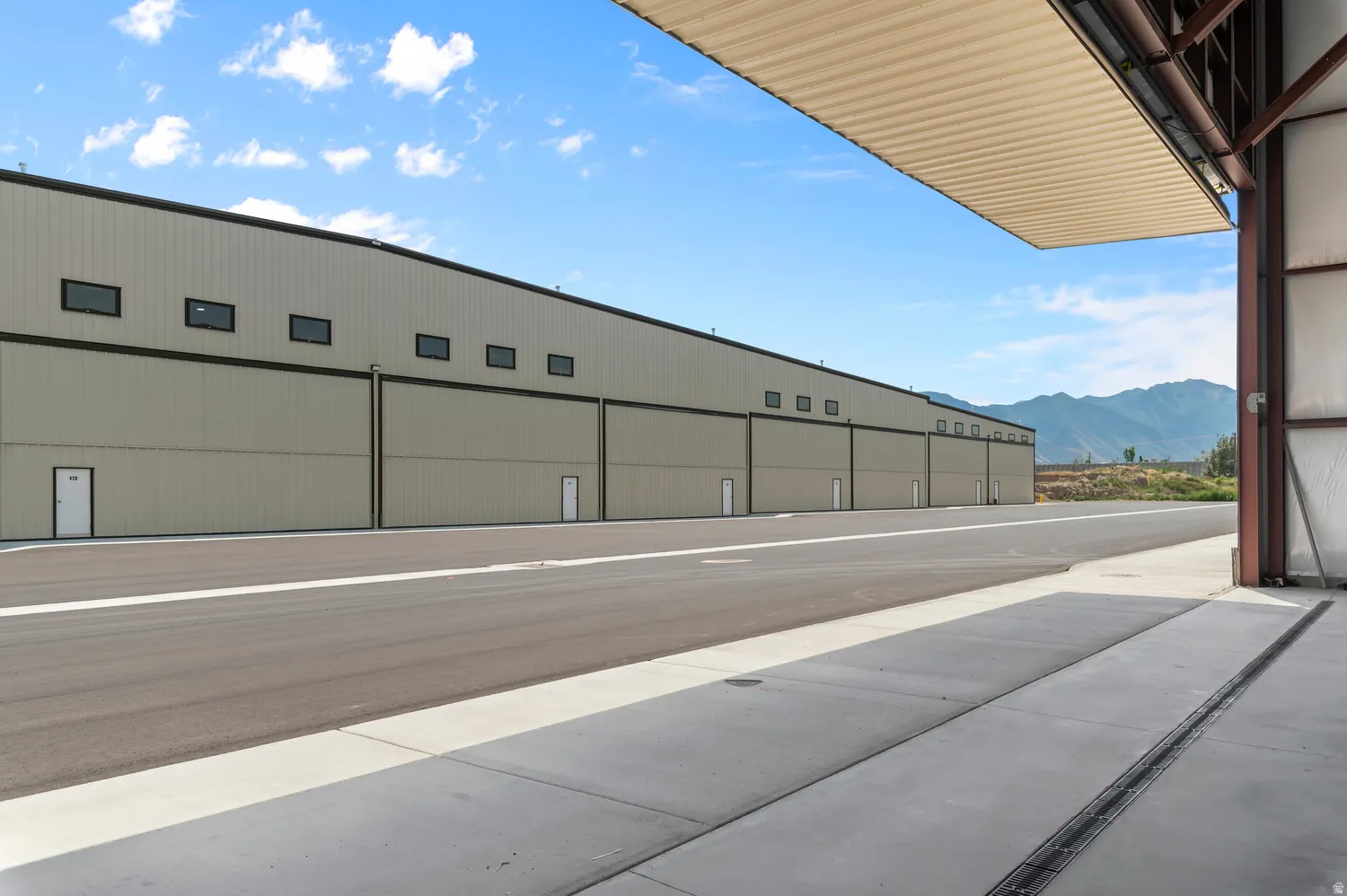Metal-sided building with multiple hangar doors and upper-level windows