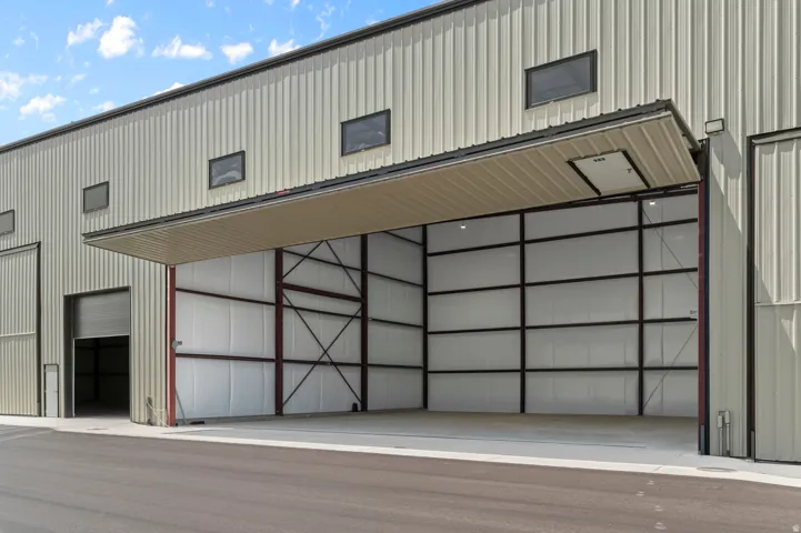 Corrugated metal exterior with multiple industrial doors, including one large bifold door