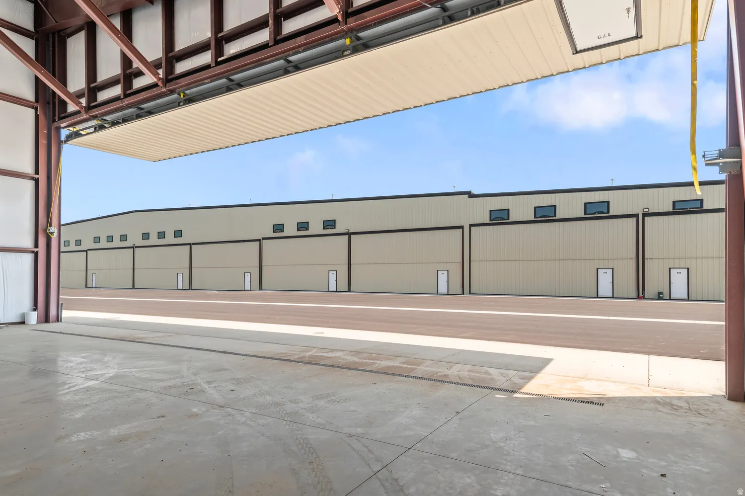 Commercial facility with a concrete floor, exposed structural beams, and a large overhead door