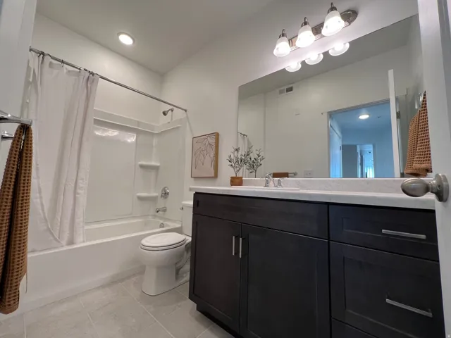 Integrated vanity with dark wood-finish cabinetry, a single basin sink, and a light-toned countertop
