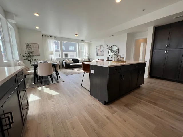 Open-concept living space featuring wood-finish flooring, recessed lighting, and expansive windows