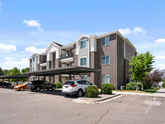 Multi-story residential building featuring brick and siding exterior,, and a covered parking structure.  This unit is located on the first floor.  ZERO stairs