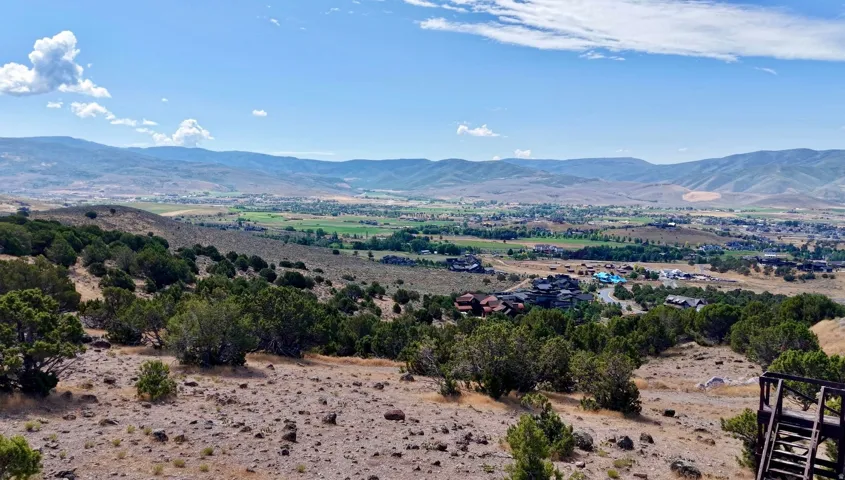 Expansive mountainous terrain with distant valley and residential structures