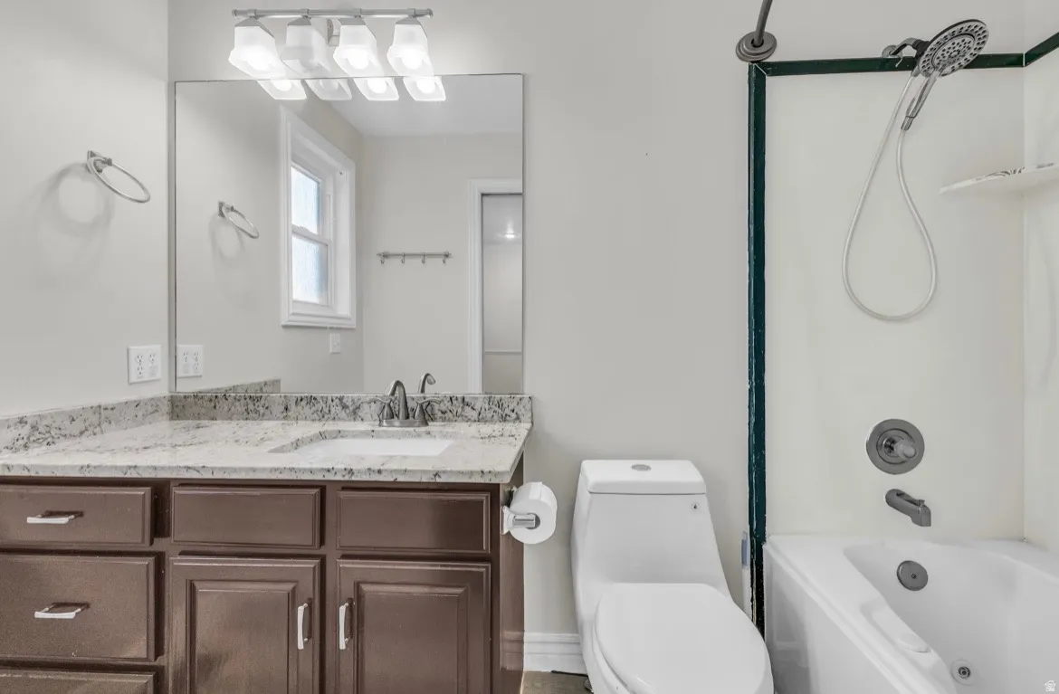 Spa-inspired primary bathroom featuring a wood-finish vanity with multiple storage drawers, granite countertop, and dual sink configuration