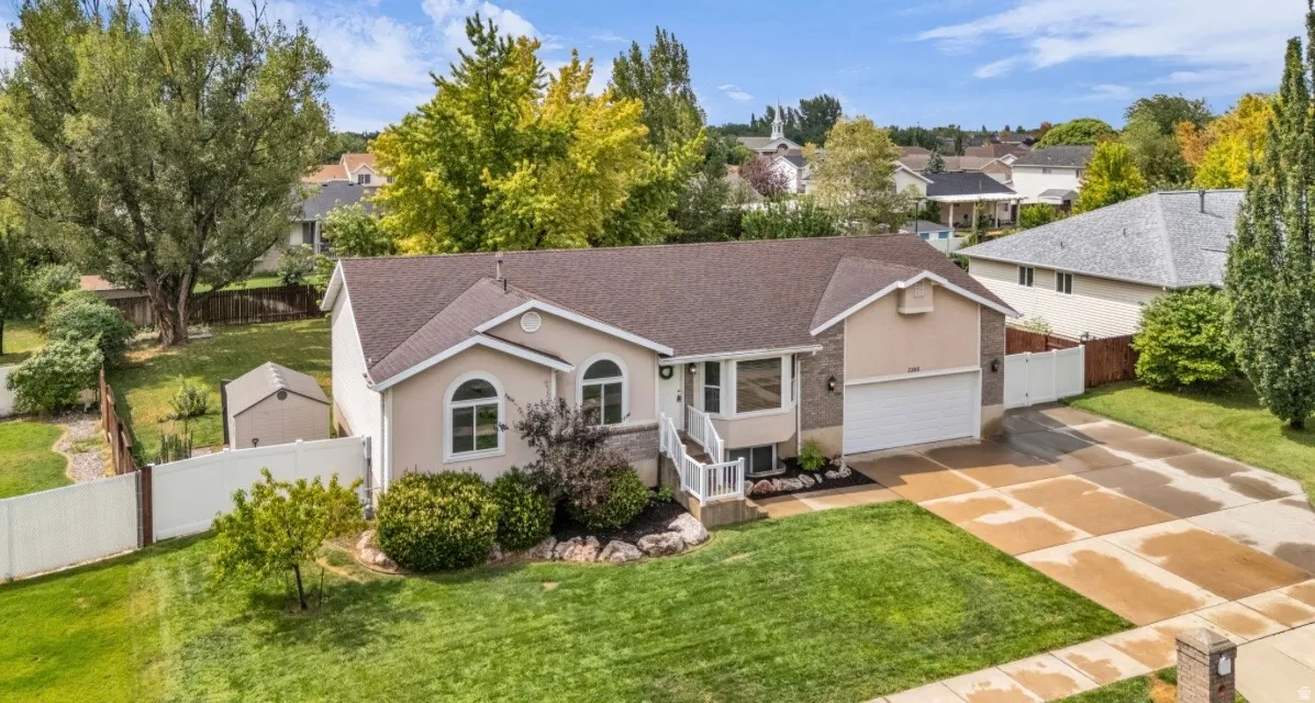 Exterior features a two-car garage, established front landscaping, and a manicured lawn