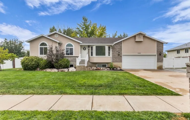 Welcoming single-story residence featuring a stucco exterior with arched windows, a covered front entry, and an attached two-car garage